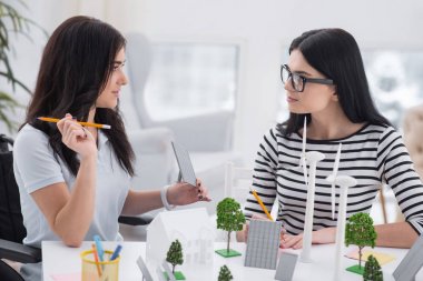 Dahi beyin fırtınası. Engelli kadın ve birbirine bakarak ve alternatif enerji modelleri ile çalışma meslektaşı musing
