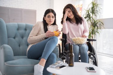 Çok korkunç. Ürküyor kız kardeşi ve patlamış mısır ile cheeps tüketen ve film ile ilgili olarak Engelli kadın