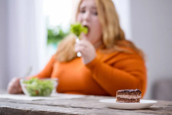 Mujer gorda desolada mirando galletas — Foto de Stock