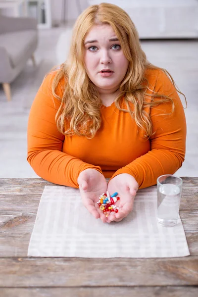 Miserable mujer gorda coloridas pequeñas píldoras — Foto de Stock