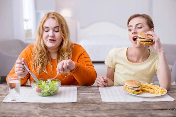 Concentrated slim woman having lunch with her friend — Stock Photo, Image