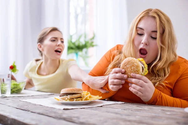 Удовлетворенная толстая женщина ест сэндвич — стоковое фото