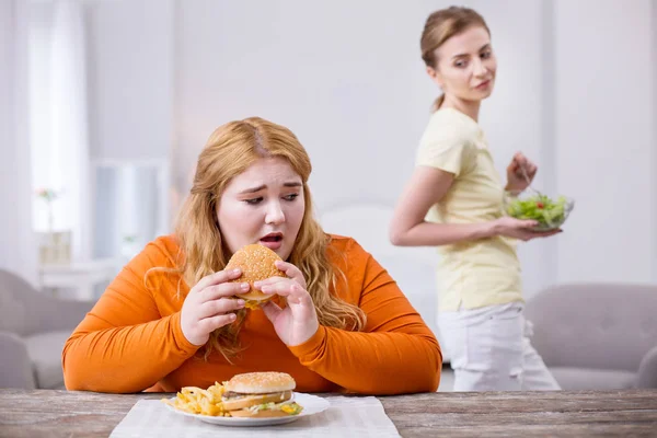 Mujer robusta triste comiendo un sándwich — Foto de Stock