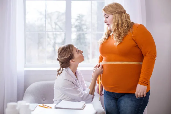 Médico insatisfeito conversando com uma mulher gorda — Fotografia de Stock