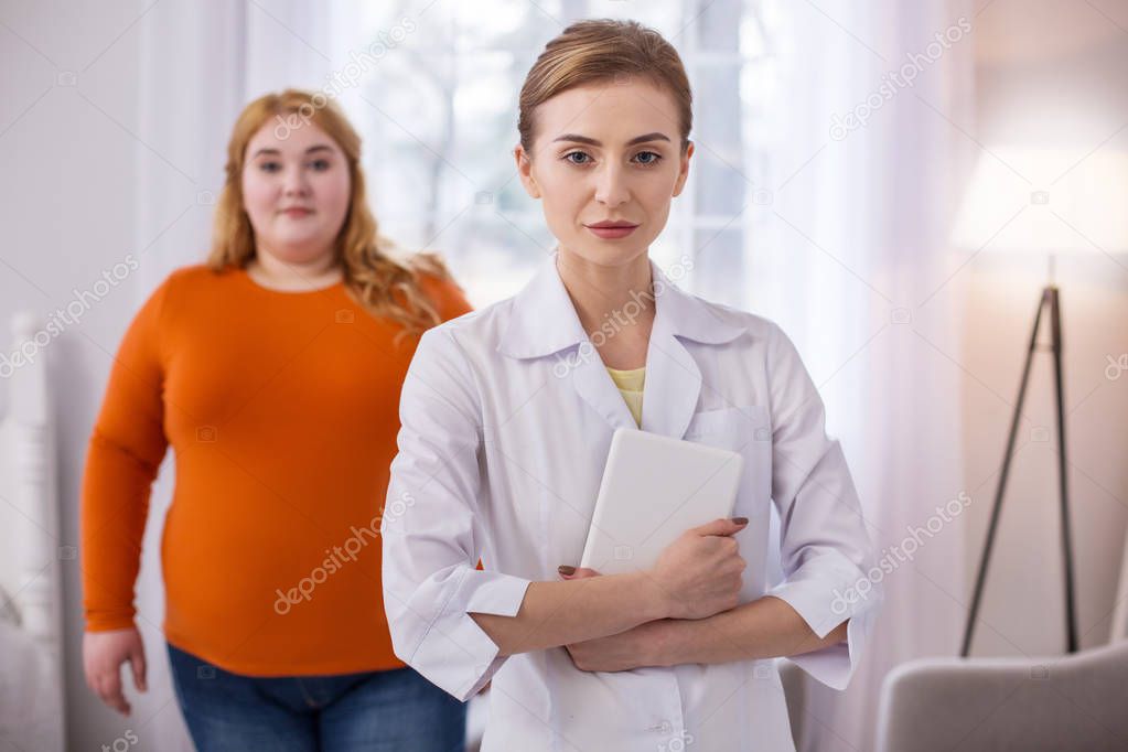 Determined nutrition specialist holding her tablet