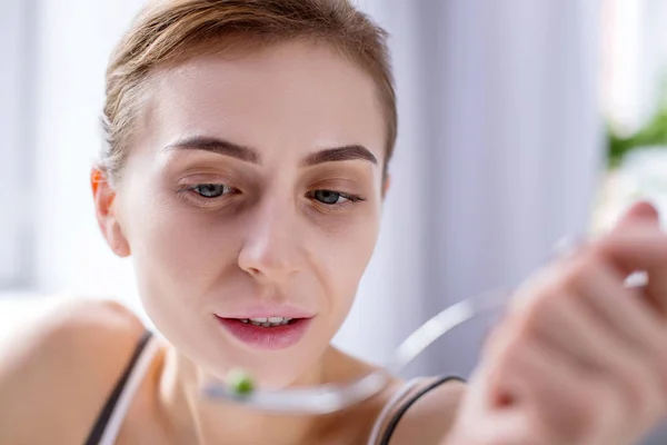 Bella giovane donna che guarda la forchetta — Foto Stock