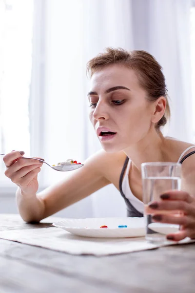 Deprimida jovem mulher tomando pílulas — Fotografia de Stock