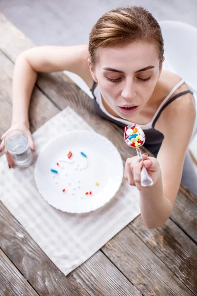 Sad ill woman taking pills — Stock Photo, Image