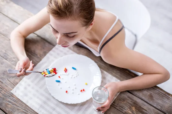 Top view of sad young woman sitting at the table — Stock Photo, Image