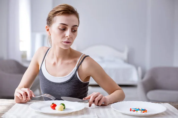 O femeie tristă deprimată se uită la pastile — Fotografie, imagine de stoc