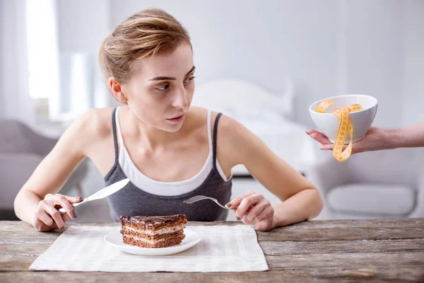 Nice young woman eating a cake — Stock Photo, Image