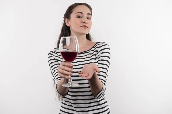 Agradável mulher atraente mostrando-lhe um copo de vinho — Fotografia de Stock