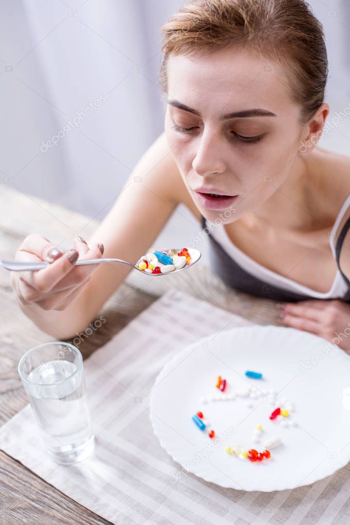 Depressed young woman taking medicine