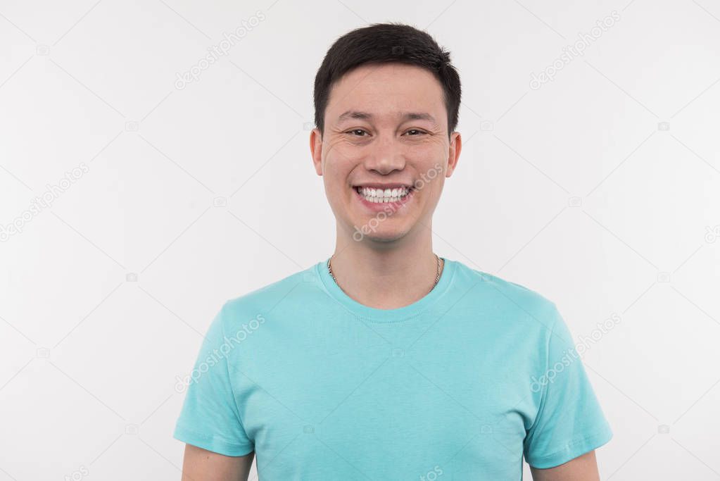 Cheerful delighted man smiling to you