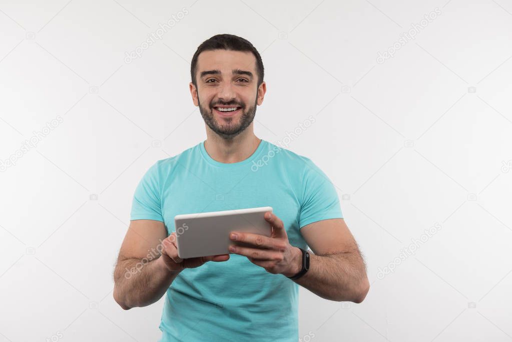 Nice delighted man holding a digital device