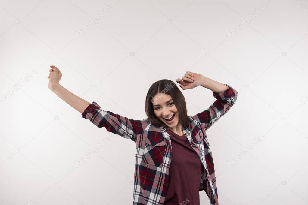 Cheerful delighted woman holding her hands up
