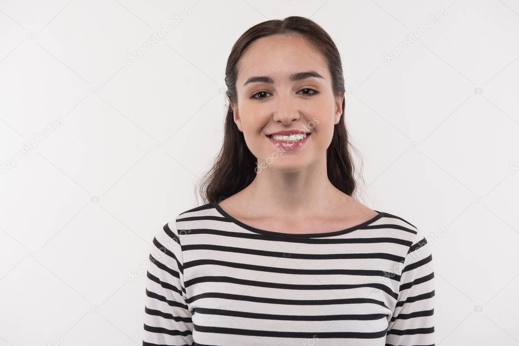 Cheerful young woman smiling to you