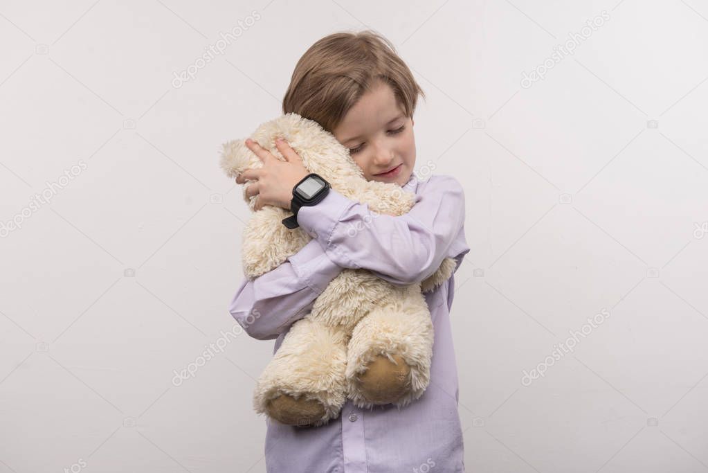 Delighted happy boy hugging his toy