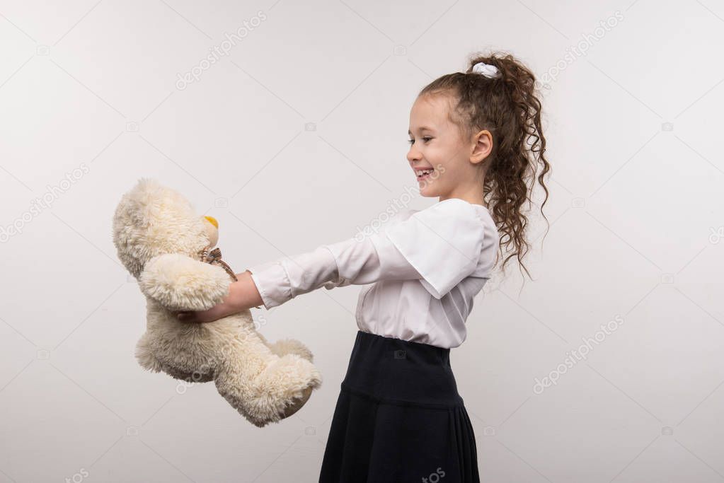 Delighted happy girl holding her bear