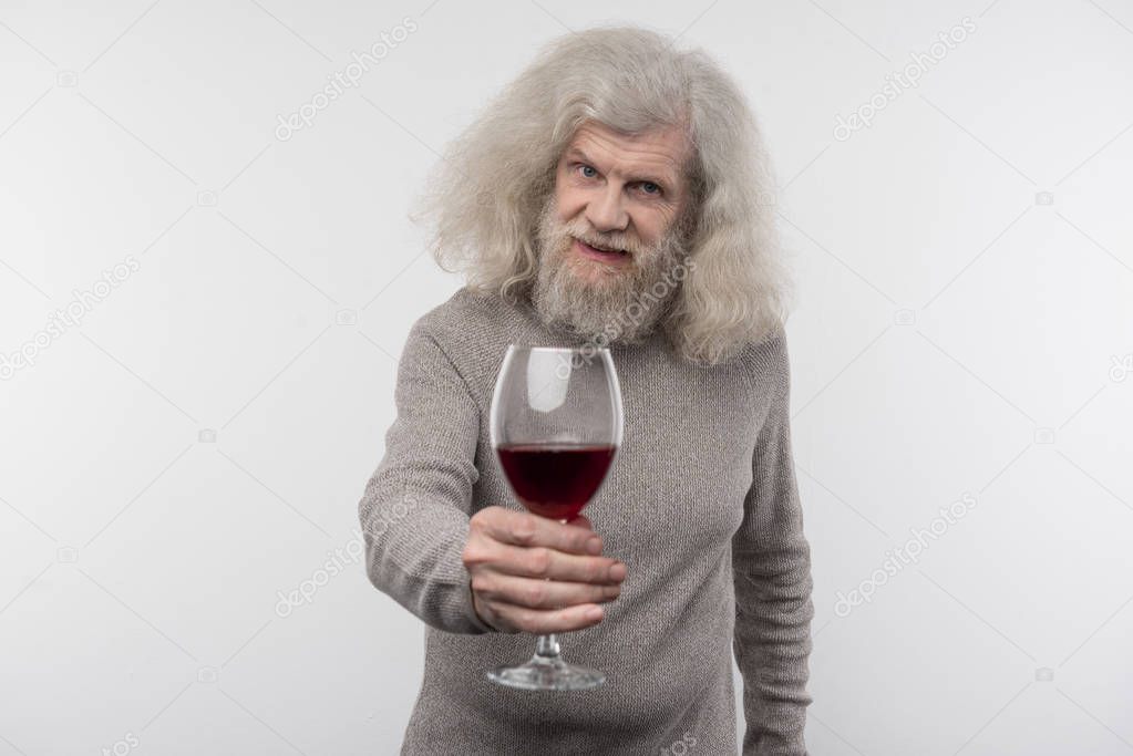 Positive aged man offering you wine