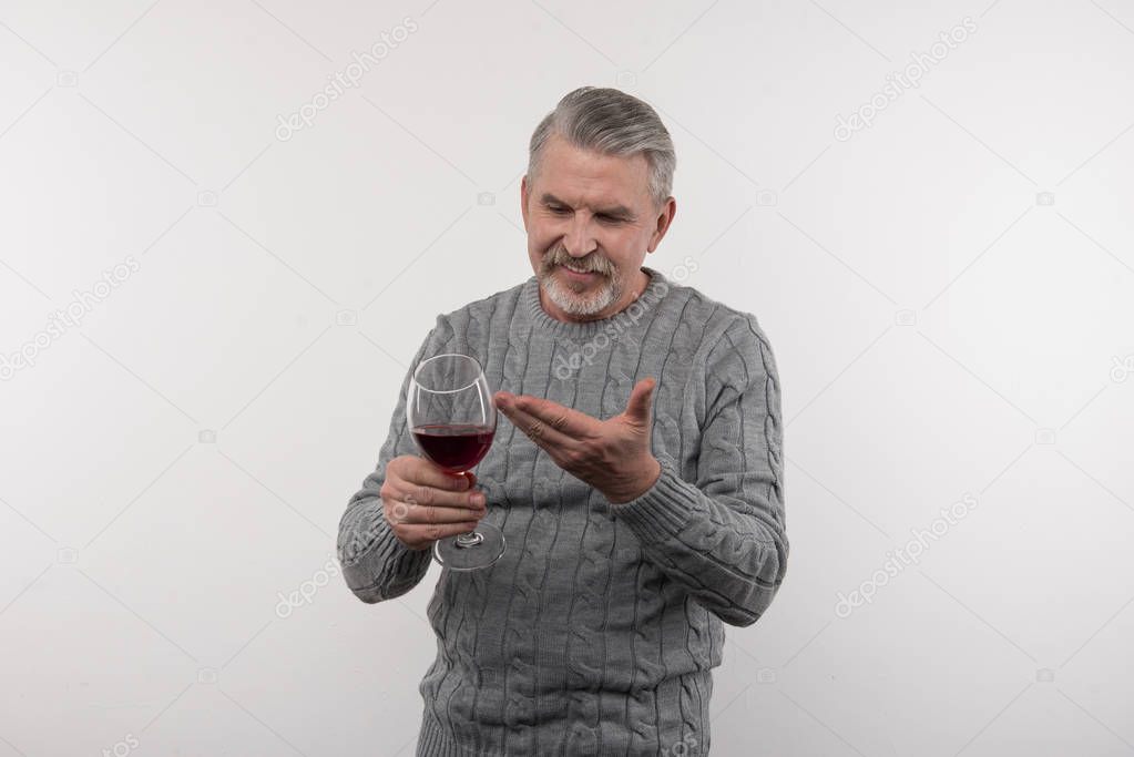 Happy positive man pointing at the glass of wine