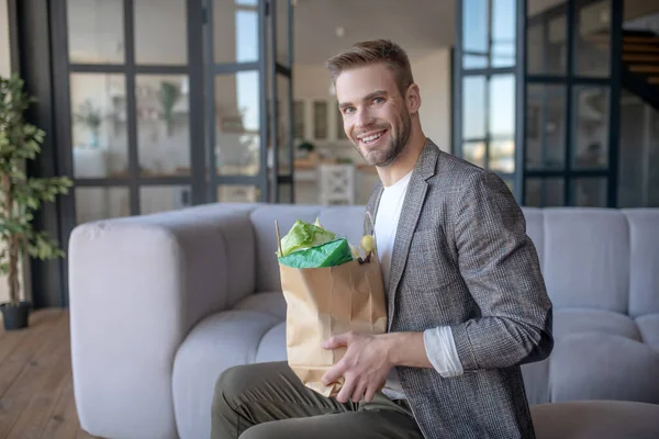 Cheerful businessman feeling good after tradition groceries shopping