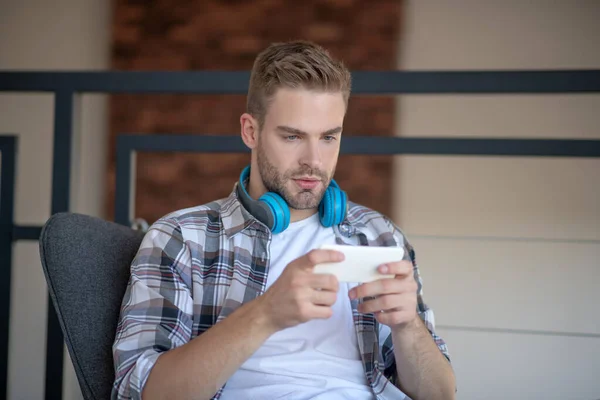 스마트폰으로 비디오 게임을 하고 있는 수염난 남자 — 스톡 사진