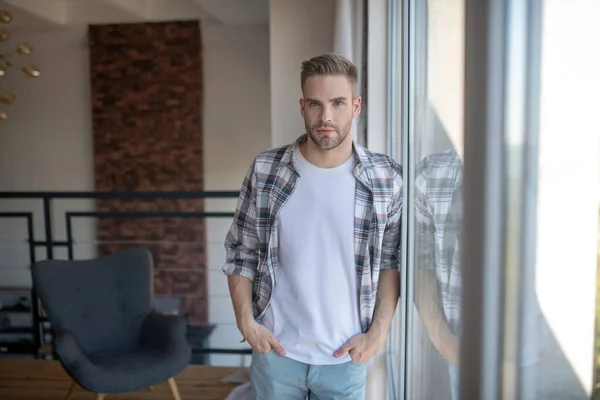 Uomo elegante che indossa camicia a quadri in piedi vicino alla finestra — Foto Stock