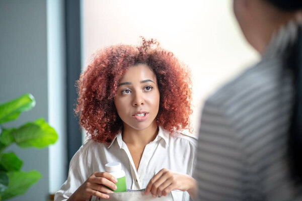 Curly stressed woman speaking with psychologist at the weekend