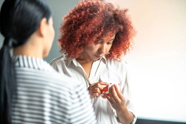 Curly gestresste vrouw lezen beschrijving van antidepressiva — Stockfoto