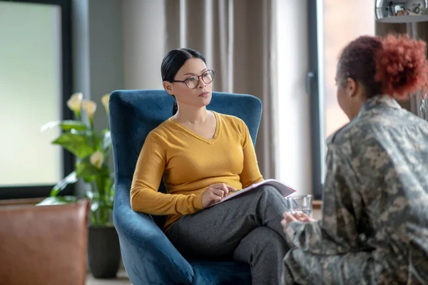 Психоаналітик слухає жінку у військовій формі — стокове фото