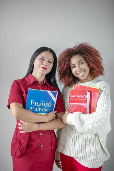 Strålande kvinnliga vänner studerar engelsk grammatik tillsammans — Stockfoto