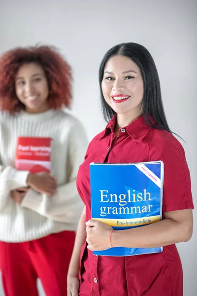 Asiatica dai capelli scuri donna in possesso di grammatica inglese libro — Foto Stock