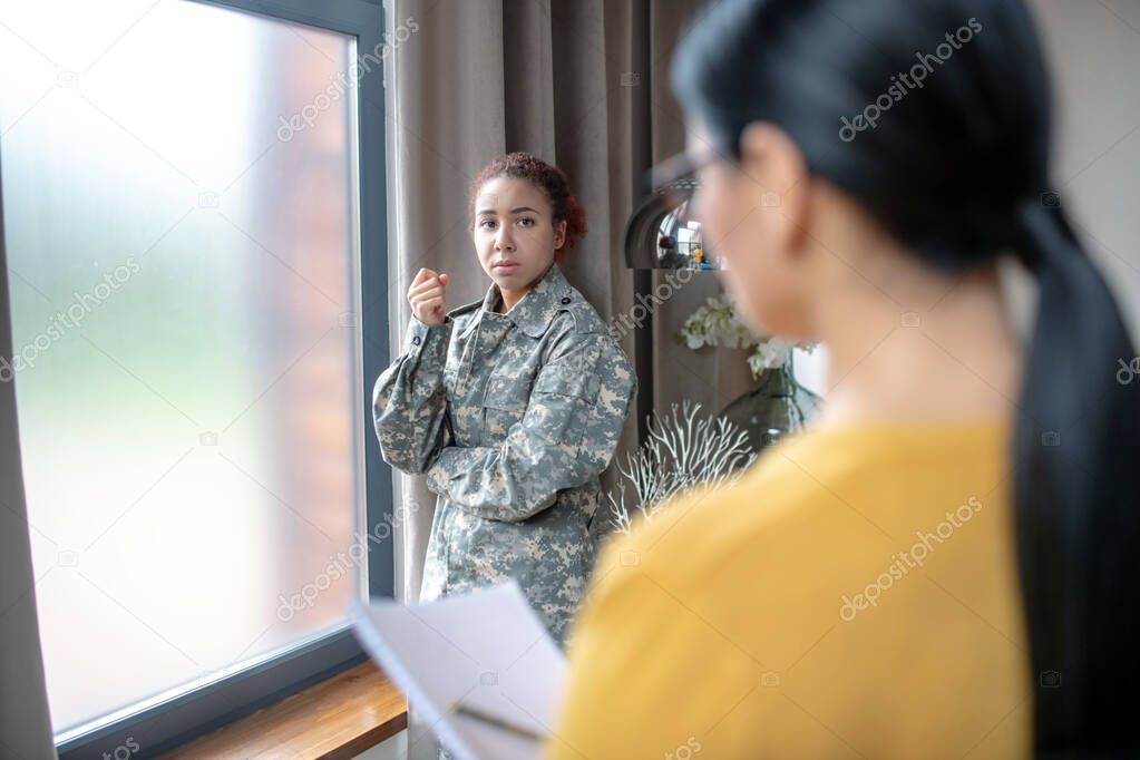 Stresse young servicewoman talking to her psychologist