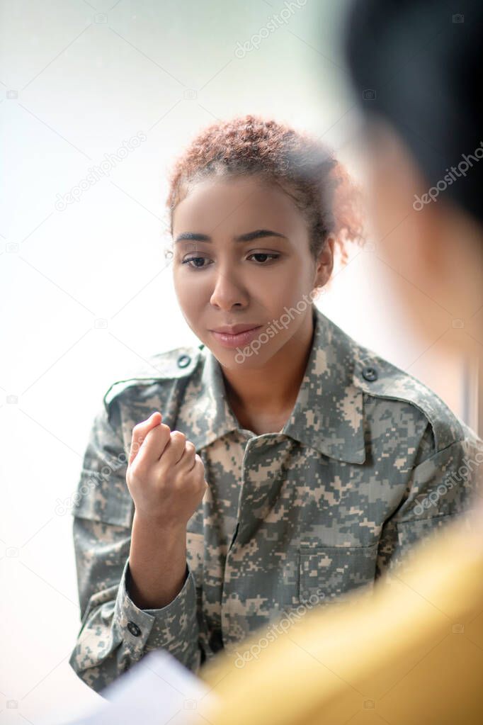 Beautiful servicewoman sharing her emotions with psychologist