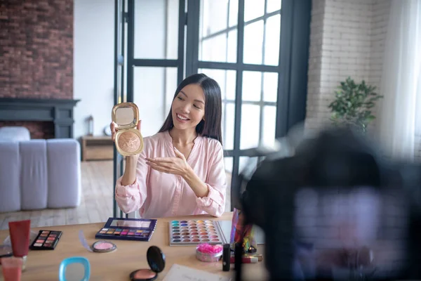 Blogger showing her favorite powder while making video — Stock Photo, Image