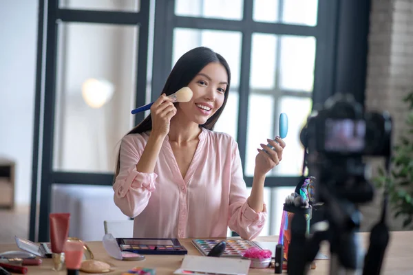 Blogger holding brush while filming makeup tutorial — Stock Photo, Image