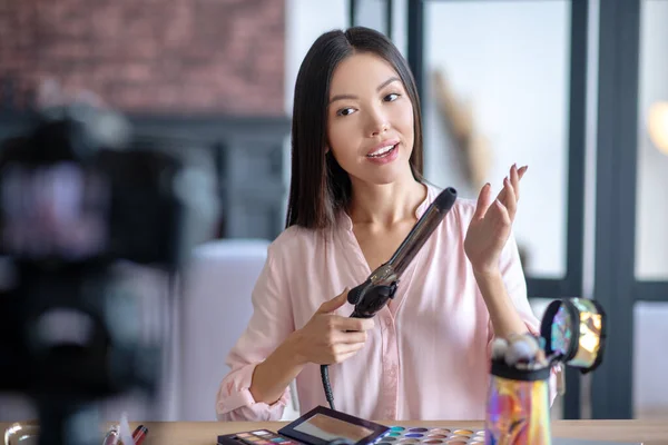 Long-haired lifestyle blogger curling her hair in front of camera — Stock Photo, Image