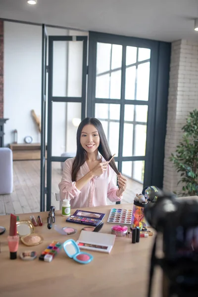 Beauty blogger kartáčování vlasy při natáčení videa o vlasy každodenní procedury — Stock fotografie