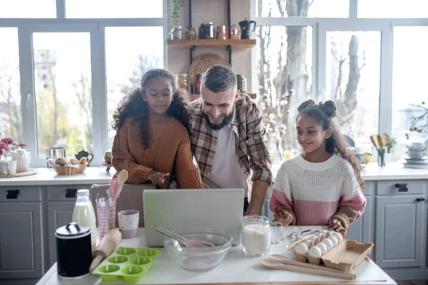 Dcery sledování recept video na notebooku s tatínkem — Stock fotografie