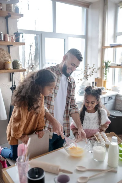 Fröhliche Töchter und Papa genießen das gemeinsame Kochen — Stockfoto