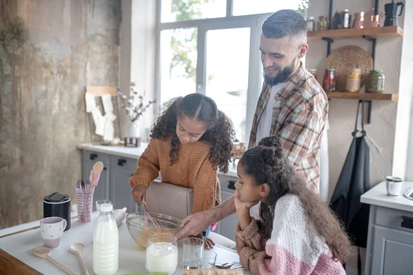 Curly meninas bonitos sentindo-se envolvido na cozinha com o papai — Fotografia de Stock