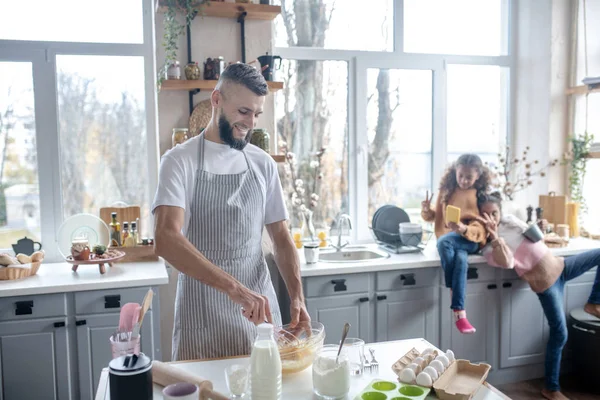 Baard man dragen schort koken taart voor hun dochters — Stockfoto