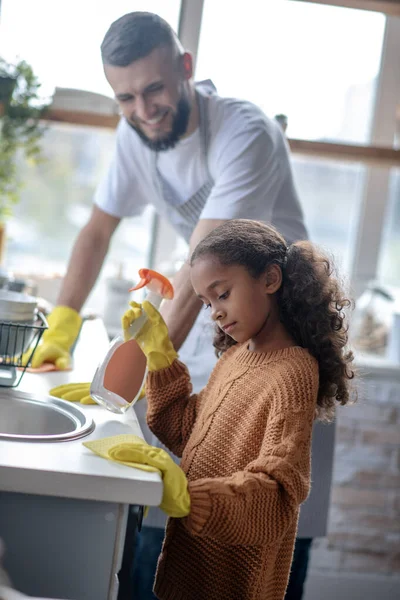 Mädchen hilft Papa beim Putzen der Küche am Wochenende — Stockfoto