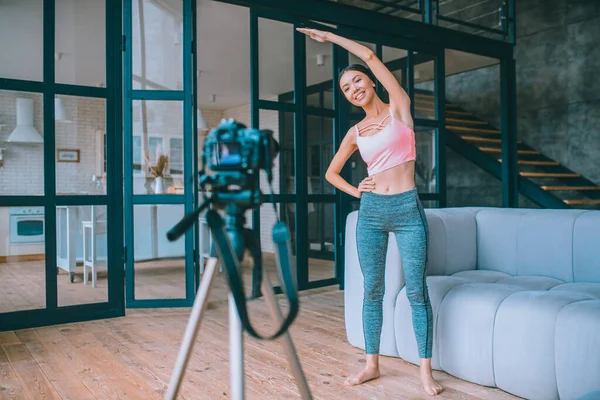 Alegre joven blogger fitness filmando ejercicios matutinos — Foto de Stock