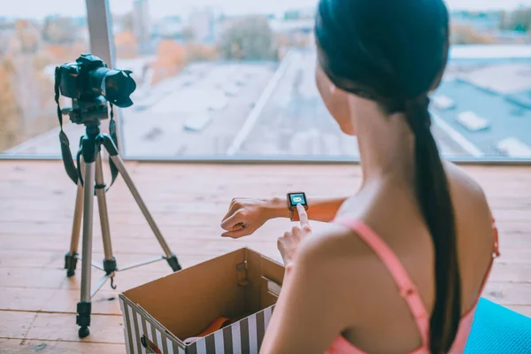 Mujer tomando reloj inteligente después de desempacar caja con regalos — Foto de Stock