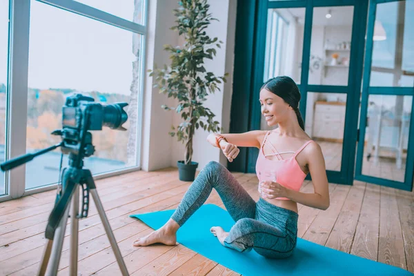 Gimnasio blogger mirando reloj inteligente y agua potable — Foto de Stock