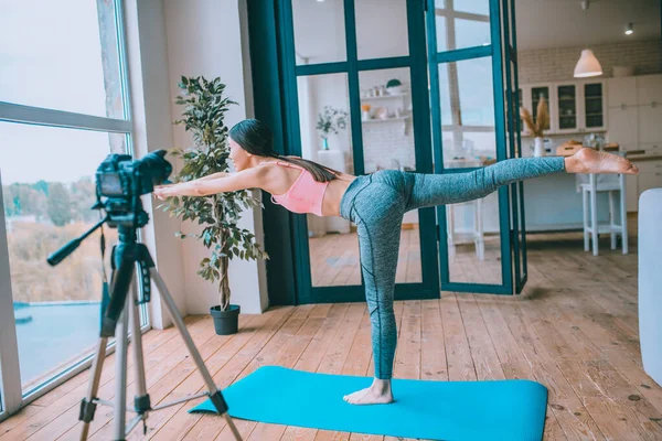 Blogger feeling good while doing yoga in front of camera