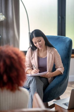 Psikanalist müşteriyi dinlerken notlar alıyor