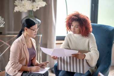 Gözlük takan olgun bir psikanalist müşteriyle konuşuyor.